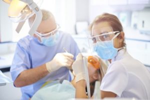 Dentist and dental assistant performing procedure on patient