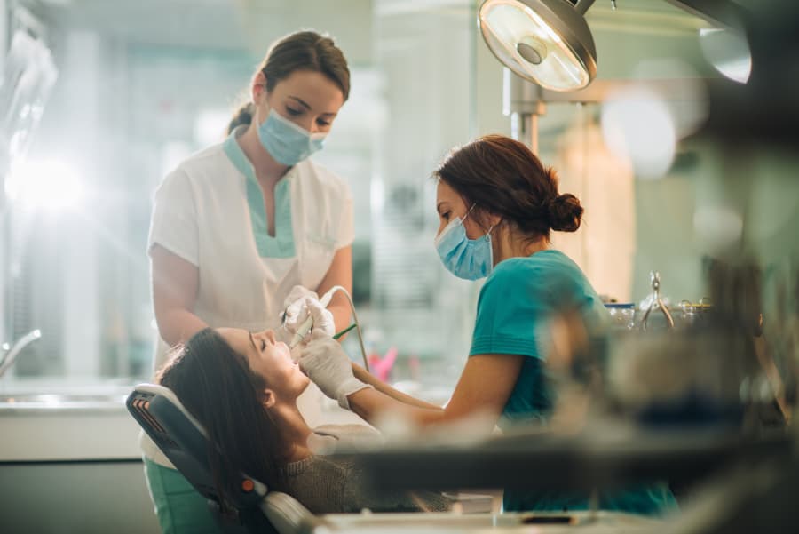 Dentist and dental assistant working on patient