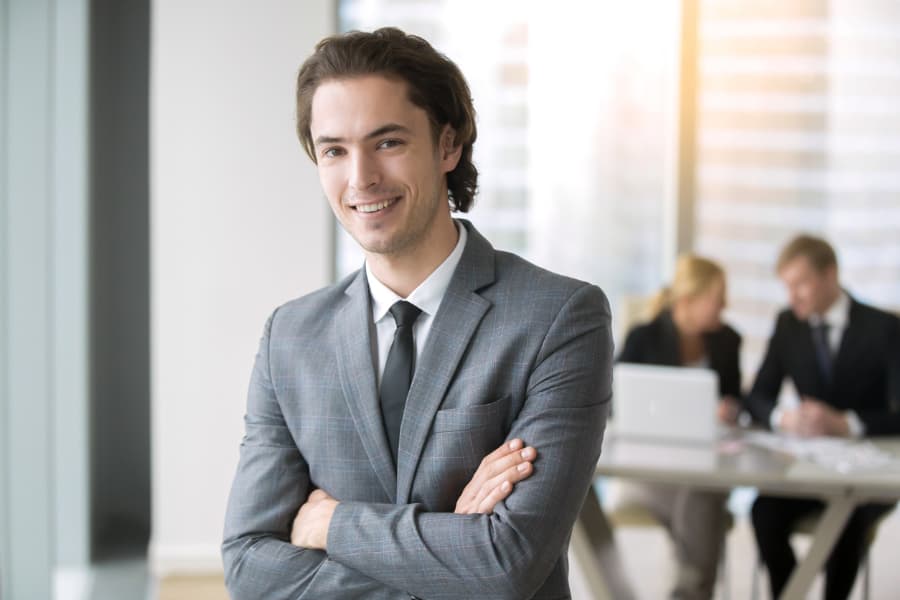 Smiling business professional standing with arms crossed