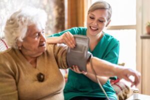 Medical assistant taking patient’s blood pressure in an assisted living center